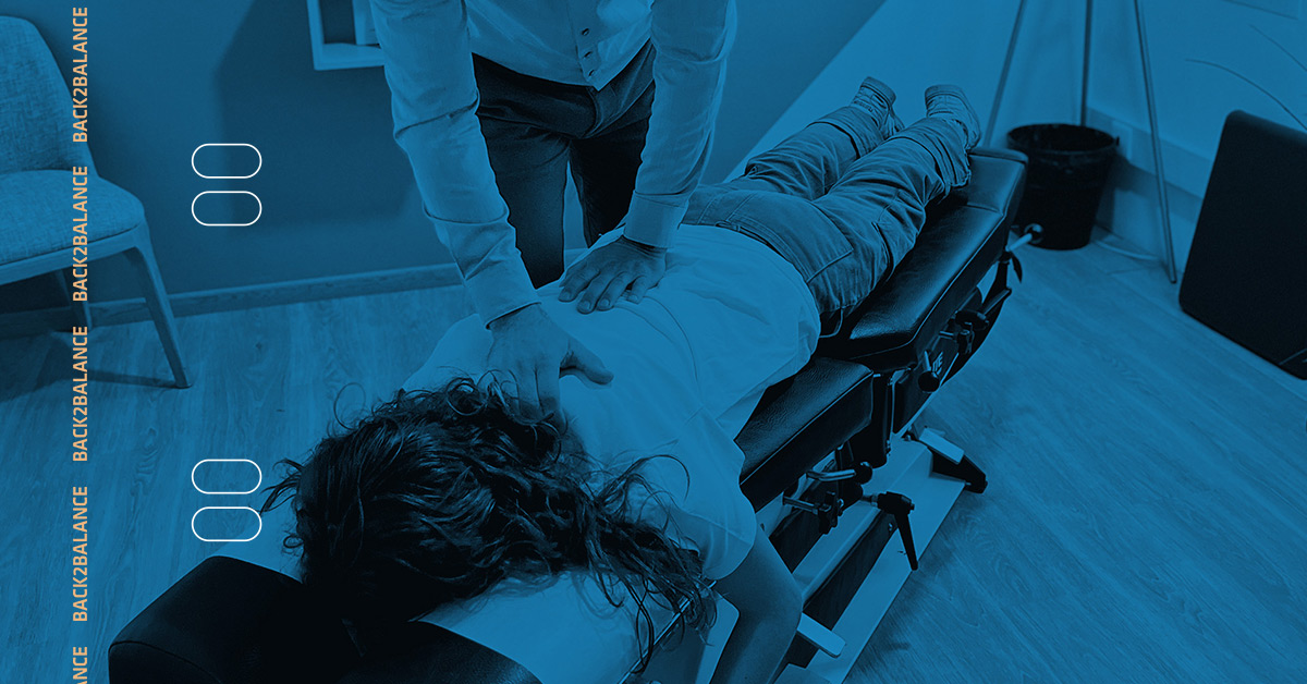 Chiropractic patient on table getting back checked by chiropractor.