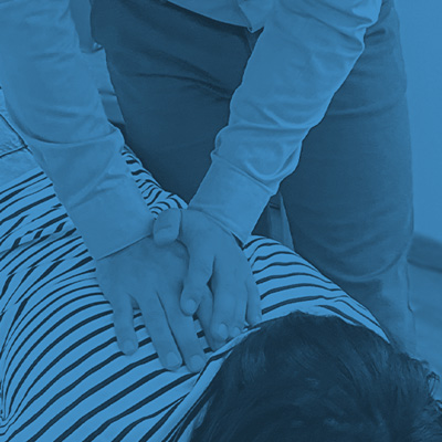 Chiropractic patient on table getting back checked by chiropractor.